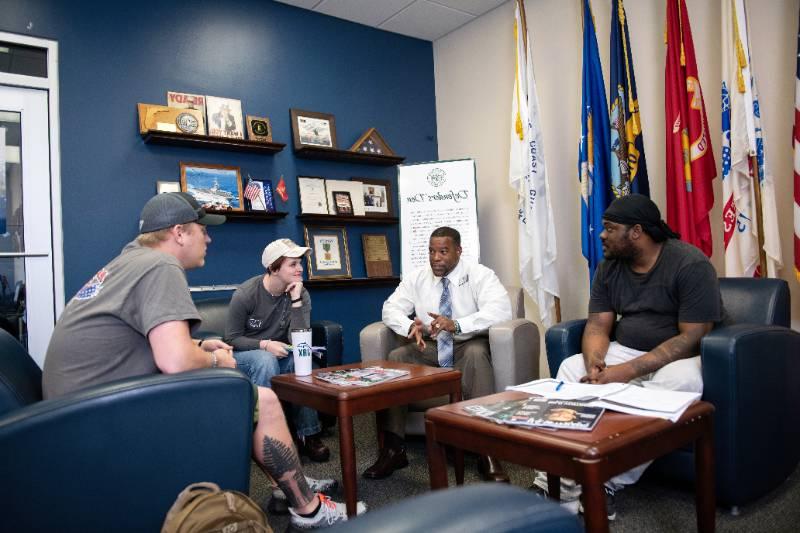 Veteran students talking with each other in the lobby of the Defenders Den on campus.