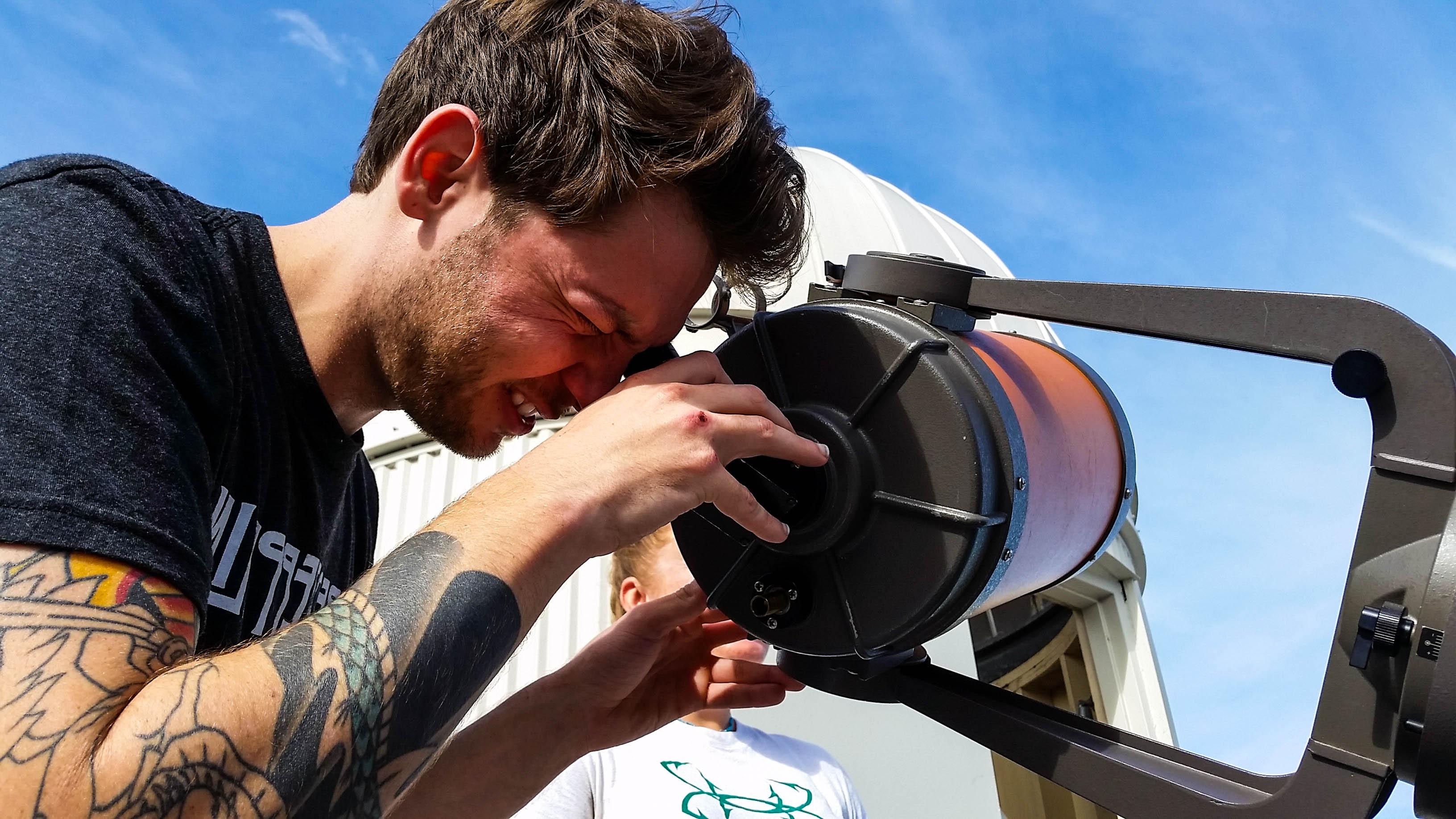 student looking into a telescope